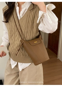 Détail du sac seau marron avec texture grainée et boucle métallique dorée élégante