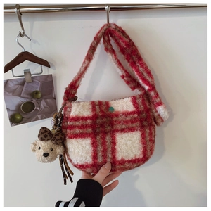 Detail of red and white checkered plush shoulder bag with cute teddy bear charm