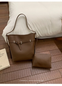 Detail of dark brown pebble leather bucket bag with matching inner pouch on a white background