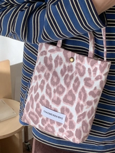Sac à main rose à motif léopard avec étiquette de marque et fermeture à pression