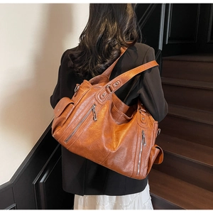 Macro shot of a vintage brown tote bag with multi-pocket details and metal zippers