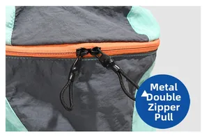Close-up of durable dual metal zippers with orange pull tabs on the gray hiking backpack