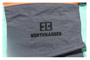 Detail of Northnansen embroidered logo on ripstop fabric of outdoor hiking backpack