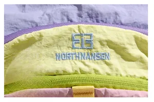Détail macro des coutures du tissu et du logo brodé sur le sac à dos de randonnée étanche