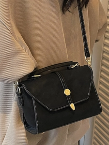 Retro black crossbody handbag with top handle and golden ornament shown on model