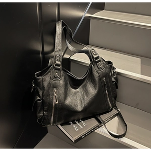 Détail du sac cabas en similicuir noir avec double fermeture éclair et anses rivetées
