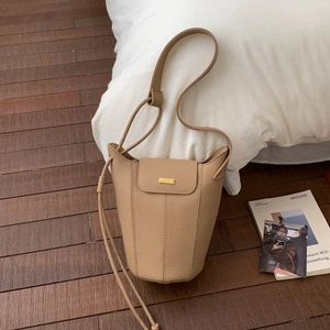 Détail du sac seau en cuir camel avec surpiqûres verticales et fermoir doré chic