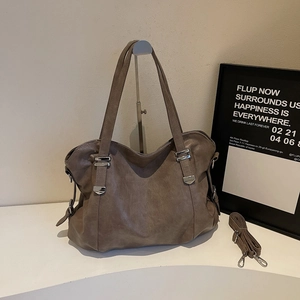 Détail d'un grand sac fourre-tout café avec boucle argentée et bandoulière amovible