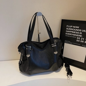 Détail d'un grand sac cabas noir en cuir texturé vintage avec garnitures argentées sur support