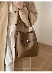 Detail of a deep brown lychee grain leather bucket bag with a minimalist retro vibe