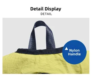 Detail showing the durable dark blue nylon handle on a contrast-colored yellow backpack