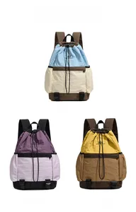 Three color-block drawstring backpacks in blue, purple, and yellow nylon fabric textures