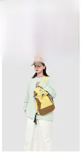 Outdoor backpack in yellow and coffee contrast colors paired with a beige baseball cap