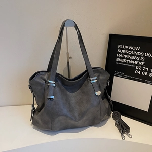 Détail du grand sac cabas gris montrant le cuir synthétique mat et les ferrures argent