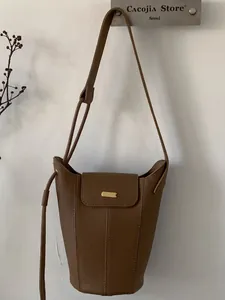 Sac seau vintage en cuir marron avec détails dorés et longue bandoulière au style de 2026