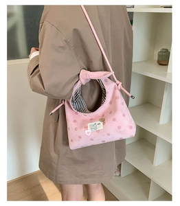 Roze polka dot stoffen crossbody tas met hartgesp en knoopdetail op de riem