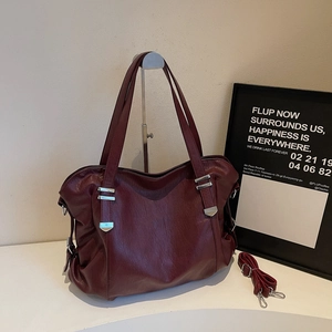 Détail du sac cabas bordeaux en similicuir avec texture fine et boucles en métal argent