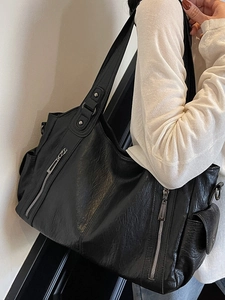 Minimalist black tote bag in lychee leather featuring silver zippers and large capacity