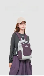 Detail view of the lightweight grey and purple Oxford fabric backpack shown on a model