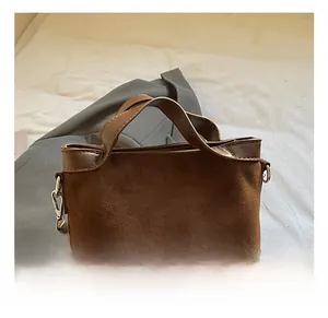 Vue détaillée du mini sac carré en daim marron avec doubles anses et boucles argentées