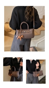 Detailed macro view of dark brown litchi pattern bag with a cute leather pony charm