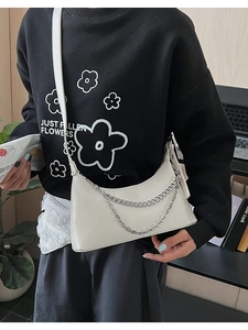 Chic white crossbody bag detail with silver chain straps and adjustable leather strap