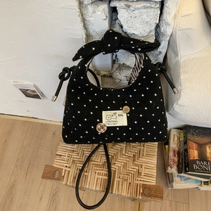 Polka dot handbag detail with bow handle and cute puppy patch on black fuzzy fabric