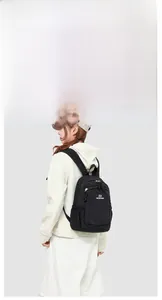 Detail view of durable black nylon backpack featuring metal zippers and elastic side pockets
