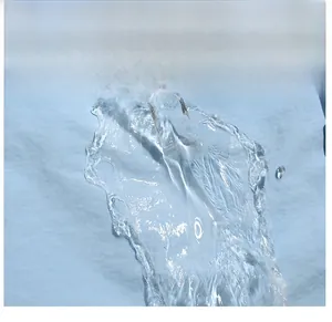Vue macro d'un tissu imperméable bleu clair montrant des gouttes d'eau sur la surface