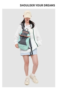 Detail of mint green hiking backpack on model showing size and sporty nylon texture