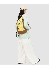 Detail of yellow and brown outdoor hiking backpack with adjustable straps and logo