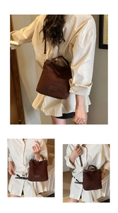 Détail du sac seau marron foncé en daim avec poignée supérieure et bandoulière