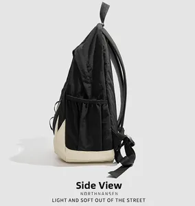 Vue latérale du sac à dos minimaliste noir et blanc avec poche latérale et détails de sangle