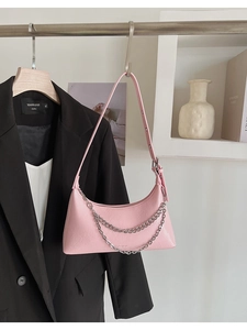 Pink hobo shoulder bag with double silver chain detail hanging in a stylish setting