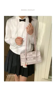 Pink tote bag detail with foal print and a cute white rabbit plush keychain accessory