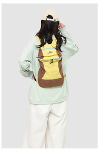 Outdoor yellow hiking backpack with brand logo and adjustable shoulder straps detail