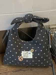Chic dark grey polka dot felt handbag featuring a large bow handle and cute girl cartoon patch