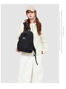 Close-up of minimalist black Oxford fabric backpack featuring dual zippers and logo detail