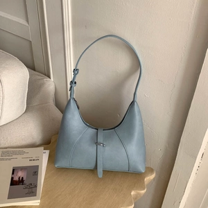 Detailed close-up of light blue crescent leather shoulder bag with silver buckle