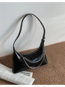 Detail view of black leather hobo bag with silver chain decor and brand lettering