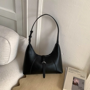Detail view of black hobo bag with silver U-shaped metal buckle and matte leather texture
