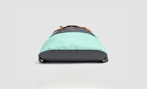 Bottom view of drawstring backpack showing mint green and orange tear-resistant fabric