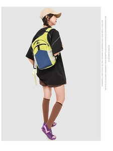 Detail of green and blue contrast backpack shown on model with double decker design