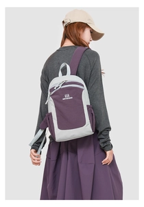 Rear view of minimalist grey and purple oxford backpack worn by a model in a studio