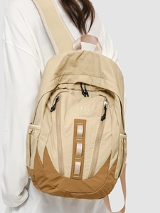 Sac à dos de voyage bicolore beige et marron avec plusieurs compartiments zippés