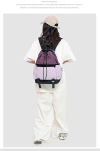 Detail view of the drawstring backpack showing the purple color-block design and logo