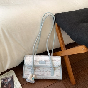 Close-up of light blue floral tote bag with cute rabbit plush charm and metal logo detail