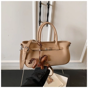 Close-up of beige crossbody bag with textured leather and brown horse charm detail