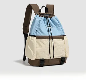 Detailed side view of nylon drawstring backpack showing three-color patchwork and side pocket