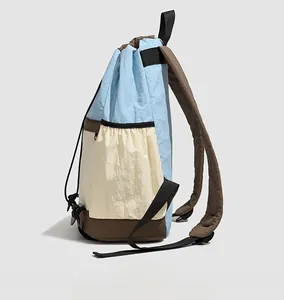 Detail view of water-resistant nylon drawstring backpack with side pocket and color blocking